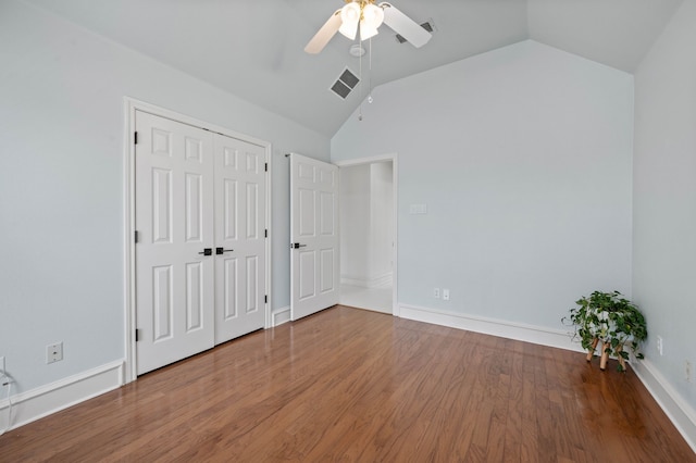 unfurnished bedroom with visible vents, ceiling fan, lofted ceiling, and wood finished floors