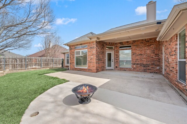 view of patio featuring an outdoor fire pit and fence