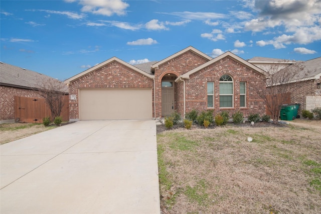 single story home with driveway, brick siding, and an attached garage