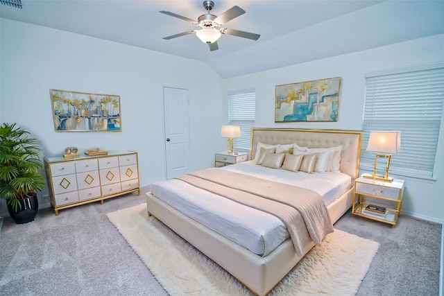 carpeted bedroom with lofted ceiling, visible vents, and a ceiling fan