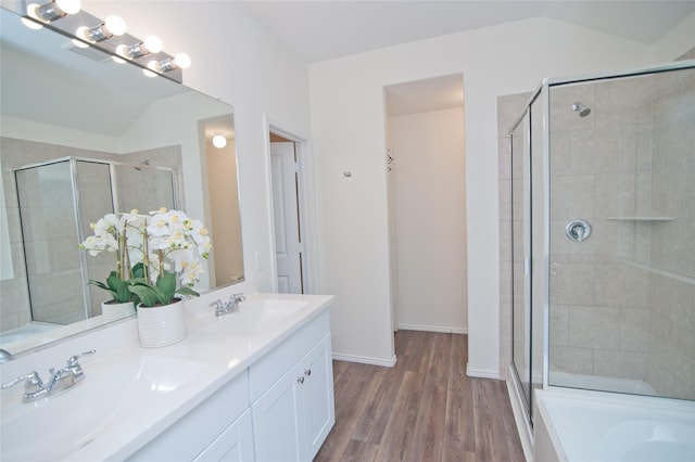 bathroom featuring wood finished floors, a stall shower, a sink, and visible vents