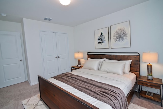 bedroom with visible vents, a closet, and light colored carpet