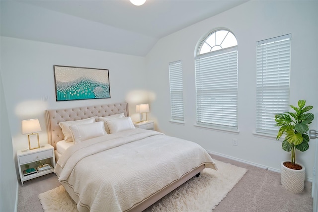 carpeted bedroom featuring vaulted ceiling and baseboards