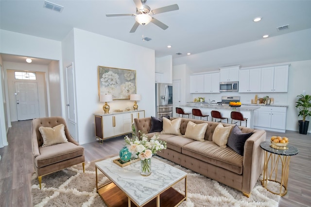 living room featuring light wood-style floors, recessed lighting, visible vents, and ceiling fan