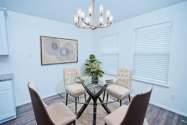 dining room with dark wood-type flooring, baseboards, and an inviting chandelier