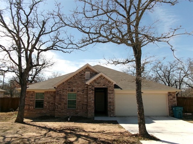 view of front of property featuring brick siding, roof with shingles, concrete driveway, an attached garage, and fence