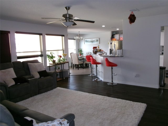 living room featuring recessed lighting, baseboards, dark wood finished floors, and ceiling fan with notable chandelier