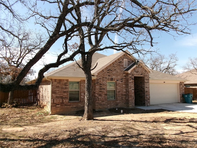 view of front of home with a garage, fence, concrete driveway, and brick siding