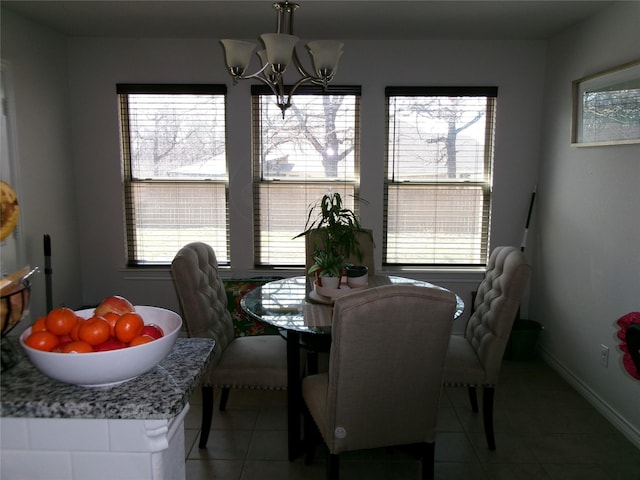 tiled dining room with baseboards and an inviting chandelier