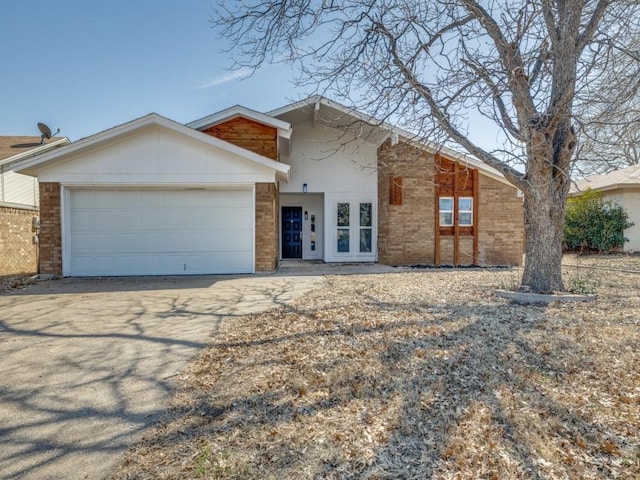 view of front of property featuring a garage, driveway, and brick siding