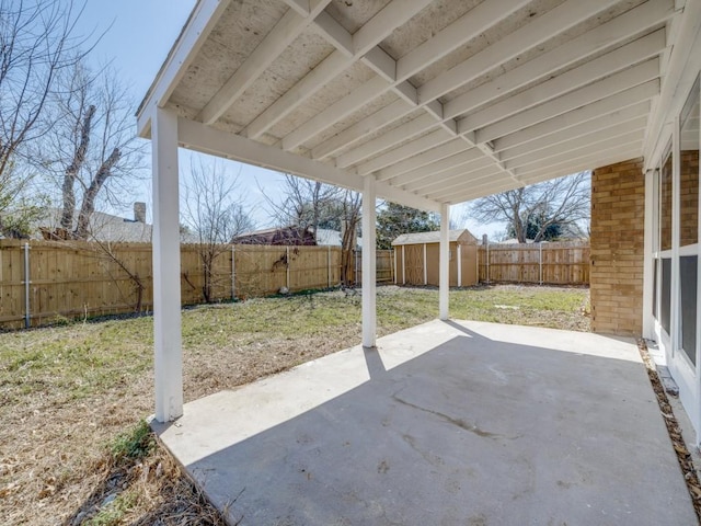 view of patio / terrace featuring a fenced backyard, an outdoor structure, and a storage unit