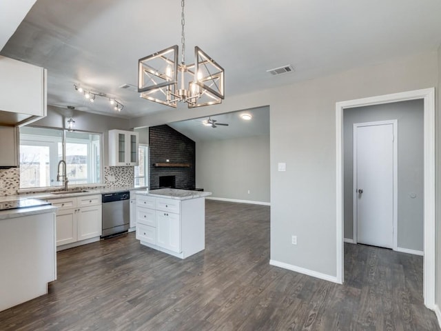 kitchen with tasteful backsplash, open floor plan, a sink, and stainless steel dishwasher