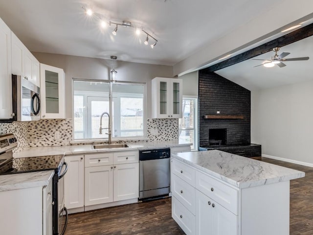 kitchen with vaulted ceiling with beams, appliances with stainless steel finishes, dark wood finished floors, and a sink