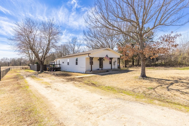 view of front of property with covered porch, driveway, and fence