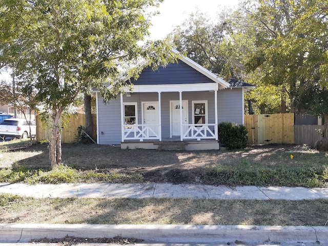 bungalow with covered porch and fence