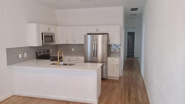 kitchen with stainless steel appliances, a sink, visible vents, white cabinets, and light countertops