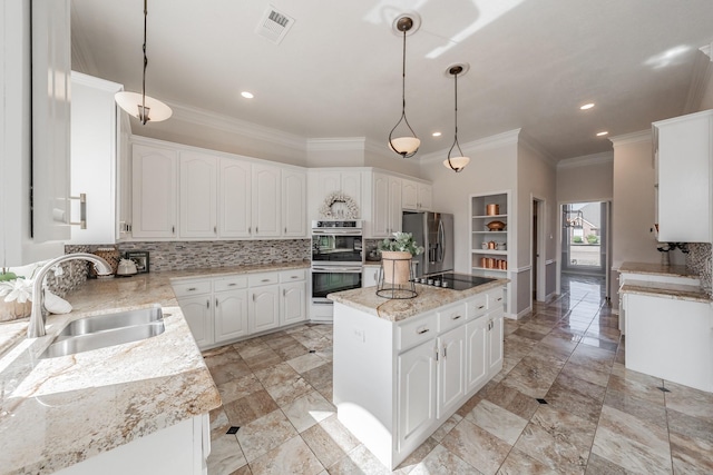 kitchen with visible vents, a center island, a sink, stainless steel appliances, and backsplash