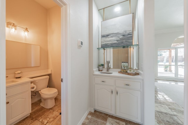 bathroom featuring ornamental molding, baseboards, vanity, and toilet