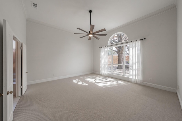 carpeted spare room featuring baseboards, visible vents, ceiling fan, and crown molding