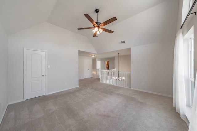 empty room with baseboards, visible vents, a ceiling fan, carpet flooring, and high vaulted ceiling