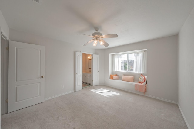 unfurnished bedroom featuring ceiling fan, connected bathroom, baseboards, and carpet flooring