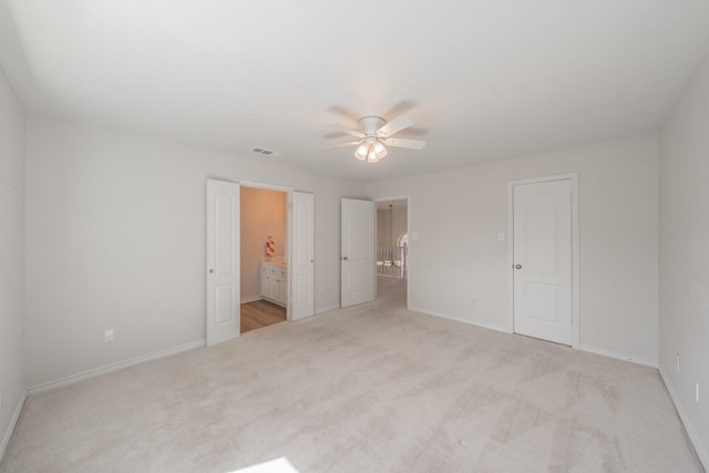 unfurnished bedroom featuring ensuite bathroom, carpet flooring, visible vents, and baseboards