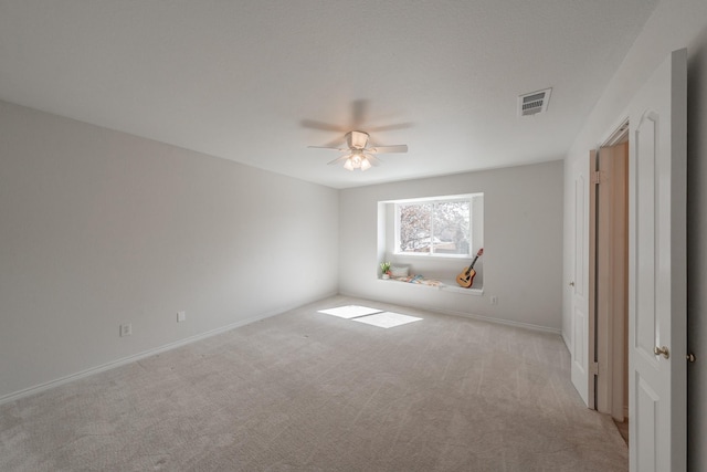 unfurnished room featuring a ceiling fan, visible vents, light carpet, and baseboards