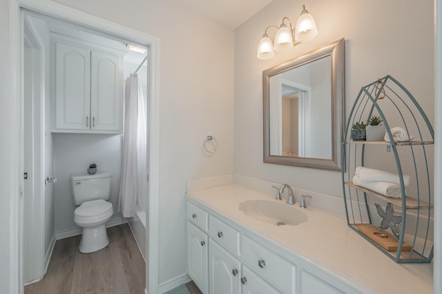 full bath featuring toilet, wood finished floors, vanity, and baseboards