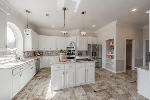 kitchen with stainless steel appliances, white cabinets, a kitchen island, and tasteful backsplash