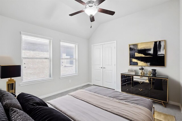 bedroom featuring a closet, baseboards, vaulted ceiling, and light carpet