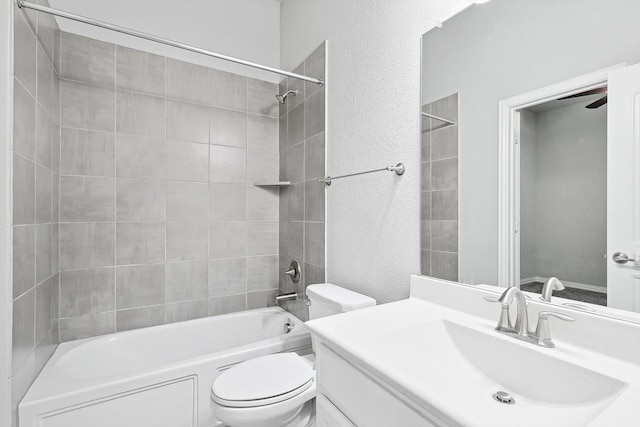 full bathroom featuring vanity, a textured wall, shower / bathtub combination, toilet, and a ceiling fan