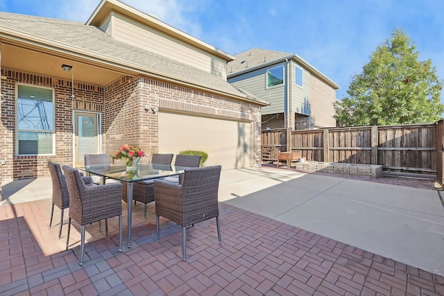view of patio / terrace with fence and concrete driveway