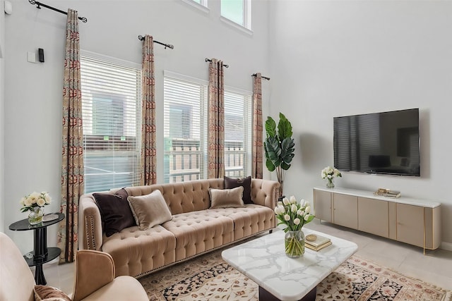 living room with light tile patterned floors and a towering ceiling