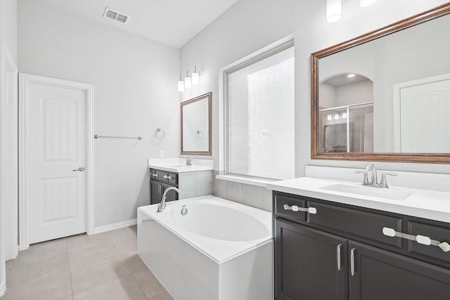 bathroom with visible vents, a shower stall, a sink, and tile patterned flooring