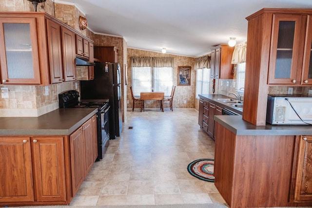 kitchen featuring dark countertops, white microwave, black / electric stove, and brown cabinets