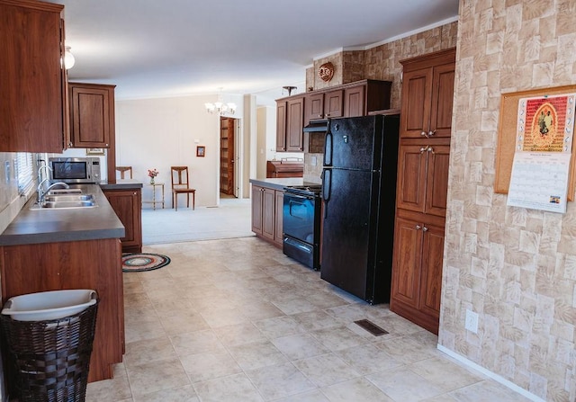 kitchen featuring visible vents, under cabinet range hood, crown molding, black appliances, and a chandelier