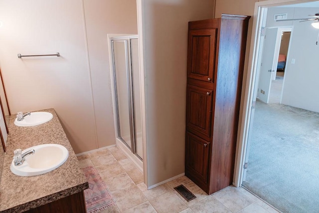 full bath with double vanity, a sink, visible vents, and a shower stall