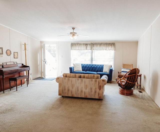 carpeted living area with plenty of natural light, a ceiling fan, and crown molding