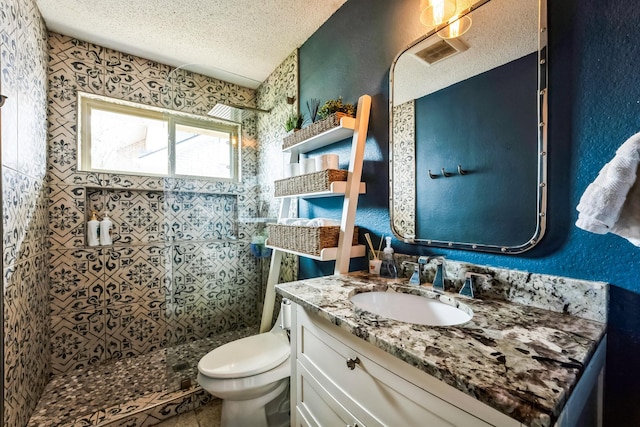 full bathroom featuring toilet, a shower stall, a textured ceiling, and a textured wall