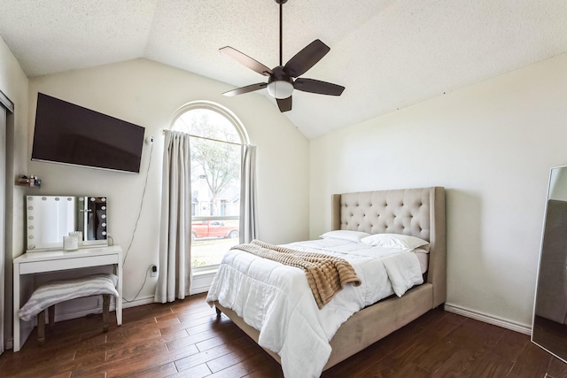 bedroom with dark wood-style floors, vaulted ceiling, a textured ceiling, and baseboards