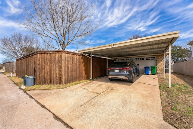 view of home's exterior featuring a garage, a carport, fence, and driveway