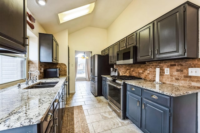 kitchen with stainless steel appliances, lofted ceiling, a healthy amount of sunlight, and a sink