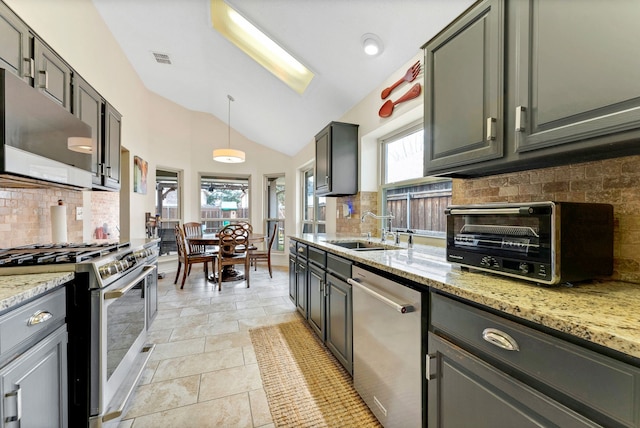 kitchen featuring lofted ceiling, a toaster, stainless steel appliances, a sink, and visible vents