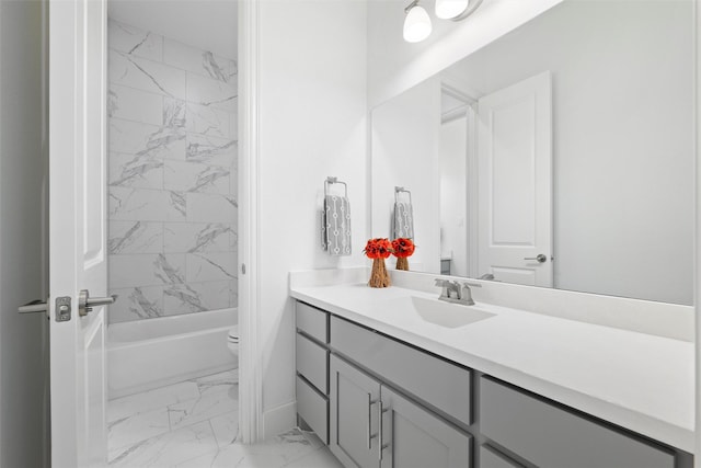 bathroom with toilet, marble finish floor, washtub / shower combination, and vanity