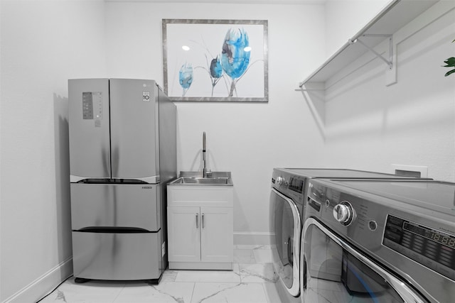 washroom with cabinet space, washing machine and dryer, marble finish floor, and baseboards