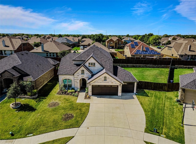 french country style house featuring fence, a residential view, stone siding, driveway, and a front lawn