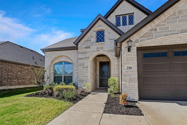 view of front facade with a garage, stone siding, roof with shingles, and brick siding