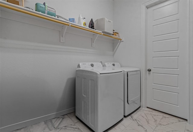 washroom with marble finish floor, washing machine and dryer, laundry area, and baseboards