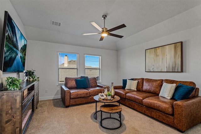 carpeted living room with lofted ceiling, baseboards, visible vents, and a ceiling fan