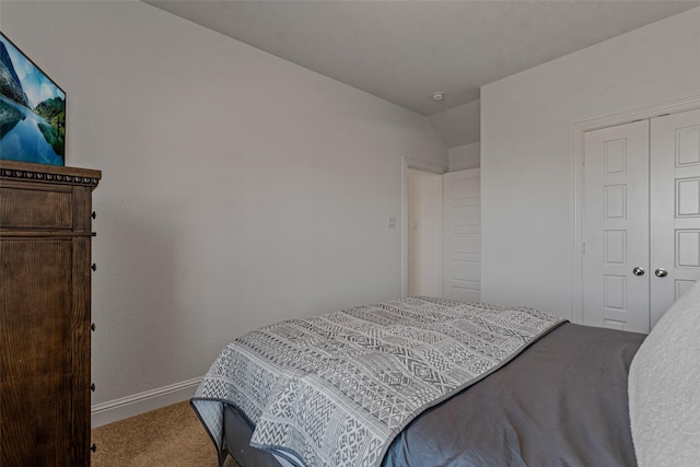 carpeted bedroom featuring baseboards and a closet